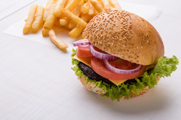 hamburger on white table with fries
