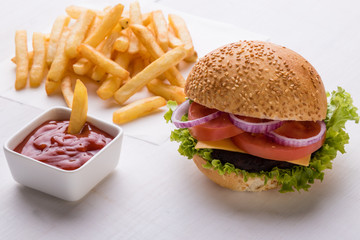 hamburger on white table with fries