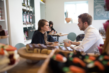  Young Couple Sitting At Table In Coffee Shop Together	