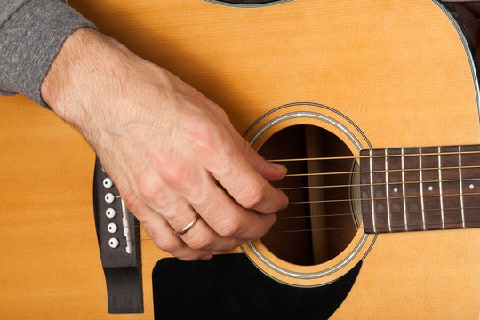 Man's hand playing the guitar.