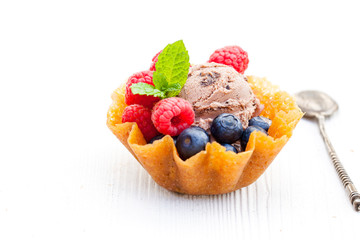 brandy  snaps basket with chocolate ice cream and berries on whi