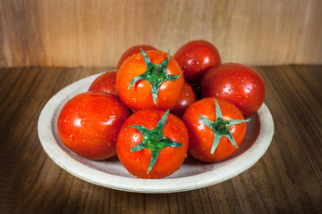 Close-up fresh ripe tomatoes on wood background