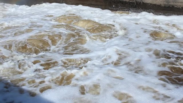 splashing waterfall and a strong swirling water with foam on Plotinka Yekaterinburg summer