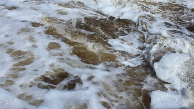 splashing waterfall and a strong swirling water with foam on Plotinka Yekaterinburg summer