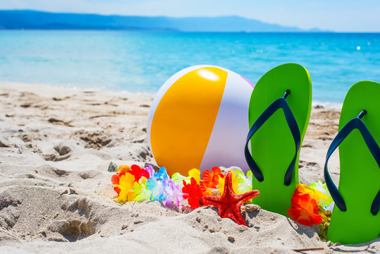 green flip flops and beach ball