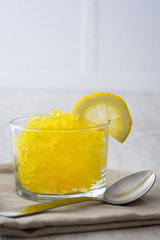 Lemon slushie in glass on white wood
