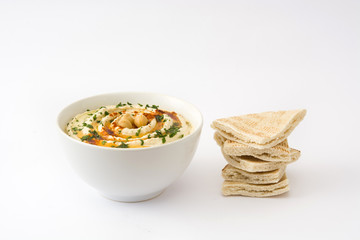 Hummus in bowl with pita bread isolated on white background