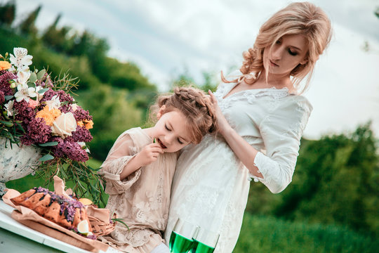 Mother with baby on picnic. Little girl eats chocolate cake. The concept of life values, peace, security and love