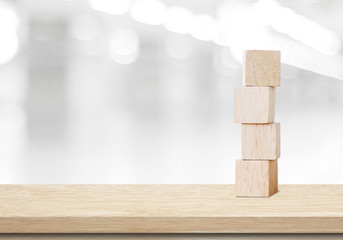 Four wooden cubes on table over blur abtract bokeh background