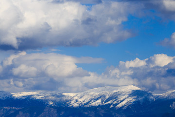 Fototapeta na wymiar Snowy mountain range with blue sky and clouds.