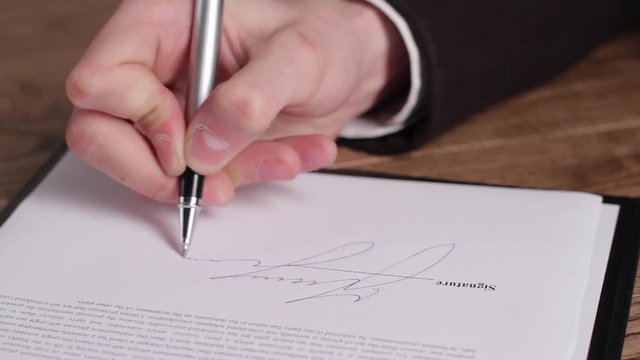Male hand signing a document. Hand with pen signs paper. Another important decision. Step towards success.