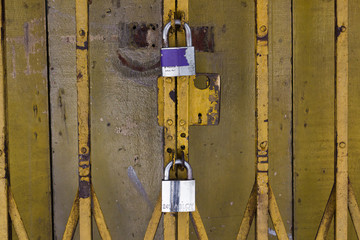 Gelbes Sicherheitstor mit zwei silbernen Vorhängeschlössern