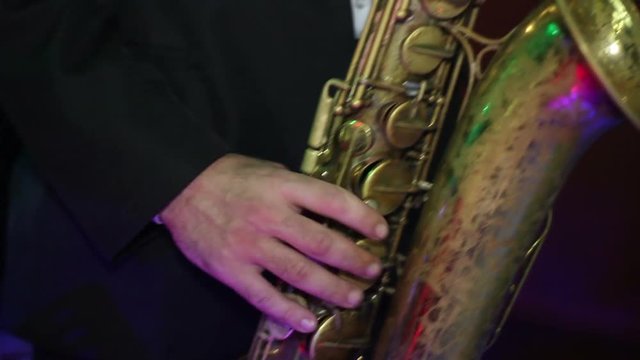 men in a black jacket  playing the old saxophone
