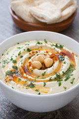Hummus with pita bread on rustic wood