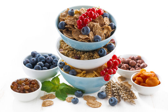 assortment of breakfast cereal in bowls, dried fruit 
