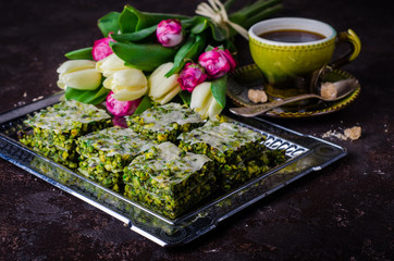 Pistachio baklava on vintage tray and dark slate background. Arabic sweets. Selective focus