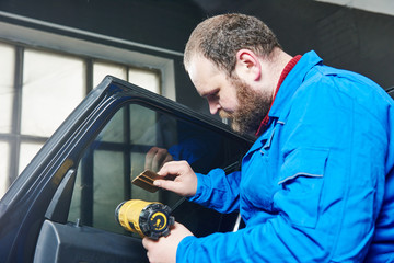 car tinting. Automobile mechanic technician applying foil 