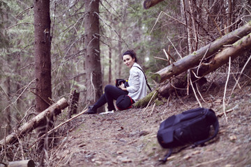 Fototapeta premium Happy young woman tourist resting on a trail in the forest