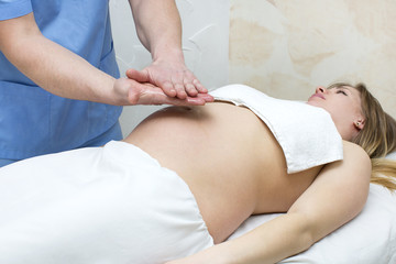 Obraz na płótnie Canvas processes salon doing massage to a pregnant woman
