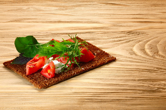 Bread crisp with tomato, cheese and arugula