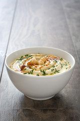 Hummus in bowl on a rustic wooden table
