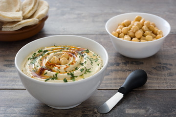 Hummus in bowl on a rustic wooden table
