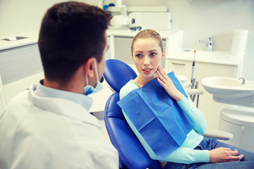 male dentist with woman patient at clinic