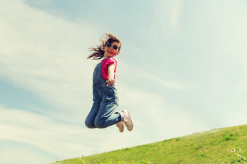 Fototapeta na wymiar happy little girl jumping high outdoors