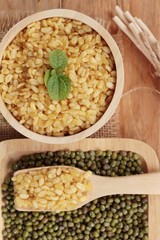 Soy beans and dry beans on wood background.