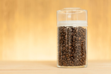coffee bean in the glass jar on wood table