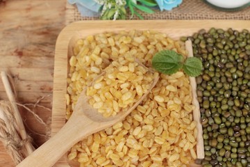 Soy beans and dry beans on wood background.