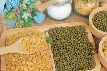 Soy beans and dry beans on wood background.