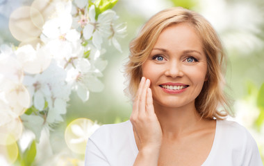 smiling woman in white t-shirt touching her face