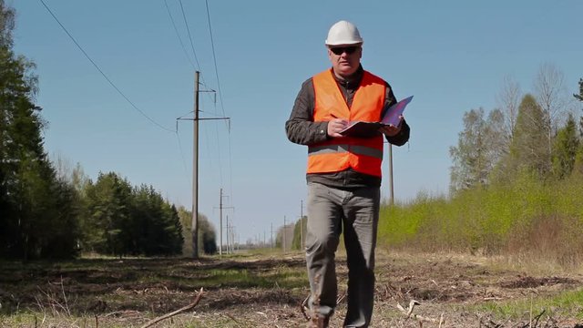 Electrician writing near the high-voltage power line
