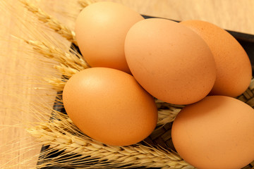 Eggs and wheat in the tray on wood table