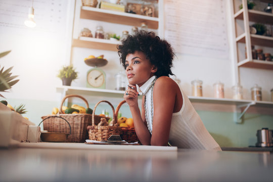 African Female Juice Bar Owner Looking Away And Thinking