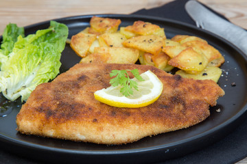Schnitzel mit Bratkartoffeln Salat und Zitrone