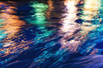 City lights reflection. Colorful glare on the water