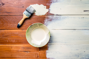 Paint brush and  bowl  of white coating color