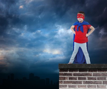 Composite image of masked boy pretending to be superhero