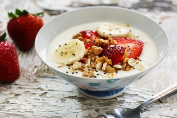 Breakfast yogurt bowl with strawberries, selective focus