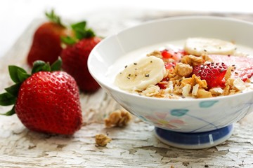 Breakfast yogurt bowl with strawberries, selective focus