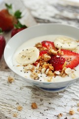 Breakfast yogurt bowl with strawberries, selective focus