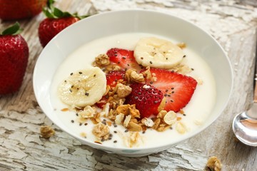 Breakfast yogurt bowl with strawberries, selective focus