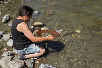 Frau beim gold waschen, suche nach goldnugget im Fluss.