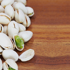 roasted and salted pistachios on wooden background