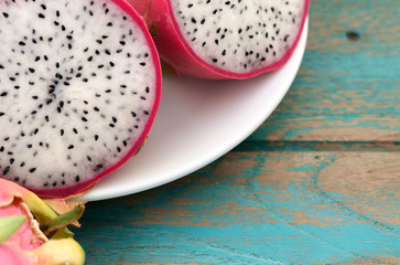 Dragon fruit / Dragon fruit on white plate, on wood background.