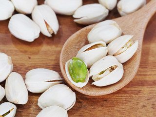 roasted and salted pistachios on wooden background