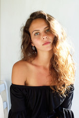 Fototapeta premium Beautiful young woman with curly hair staring