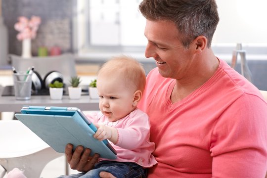 Father and baby daughter using tablet